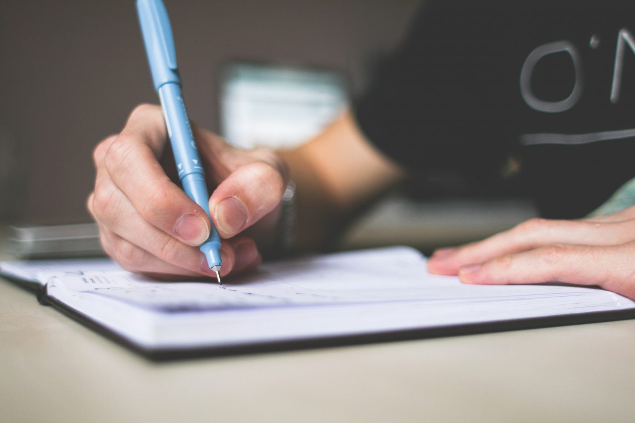 https://www.resumemasters.com.au/wp-content/uploads/2019/12/person-holding-blue-ballpoint-pen-writing-in-notebook-210661-1280x853.jpg